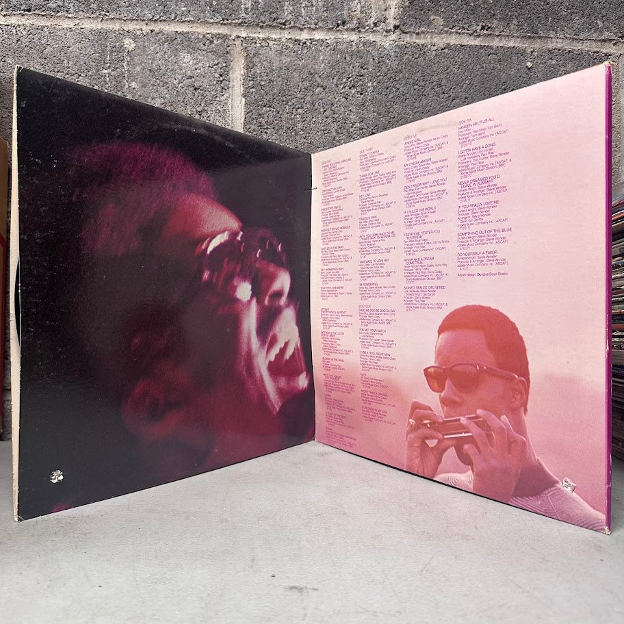 Vinyl record with a cover featuring a person with sunglasses against a textured wall.