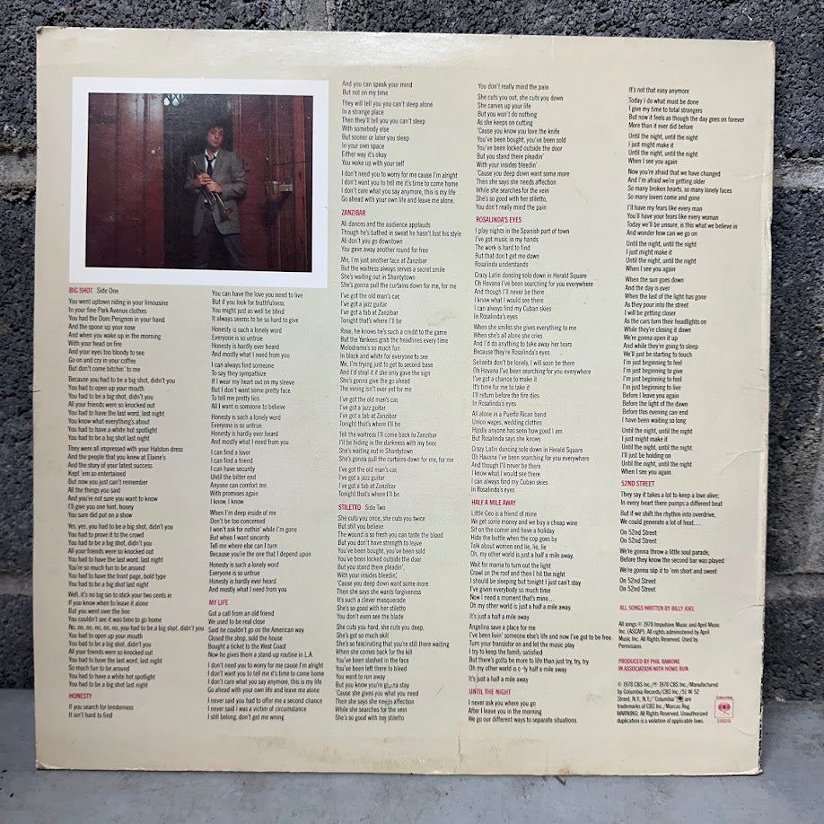Vinyl record sleeve with text and a small photo of a person against a textured wall.