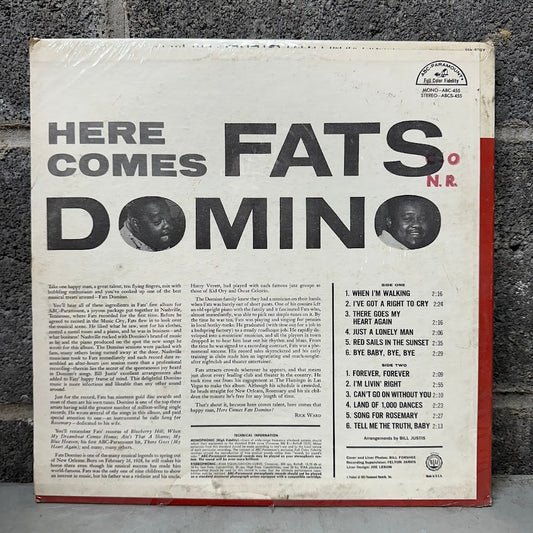 Vinyl record cover for 'Here Comes Fats Domino' with text and album details.