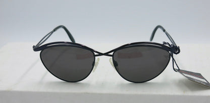A pair of Paloma Picasso sunglasses with a dark blue frame, displayed on a flat surface.