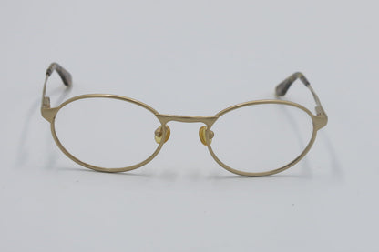 Gold-framed eyeglasses on a light gray background