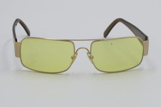 Sunglasses with gold frame and yellow-tinted lenses on a white background