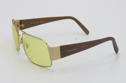 Sunglasses with gold frame and yellow-tinted lenses on a white background