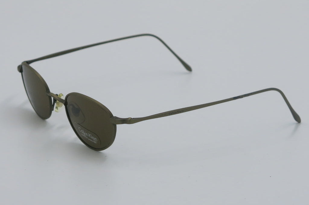 Sunglasses with thin metal frame on a light gray background