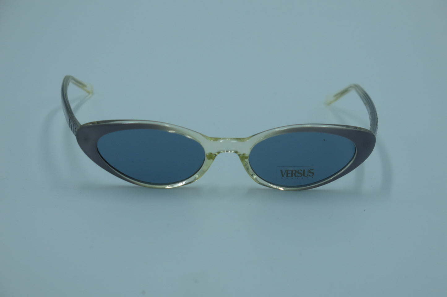Sunglasses with 'Versus' branding on a light blue background