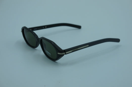 Black sunglasses with green lenses on a light gray background