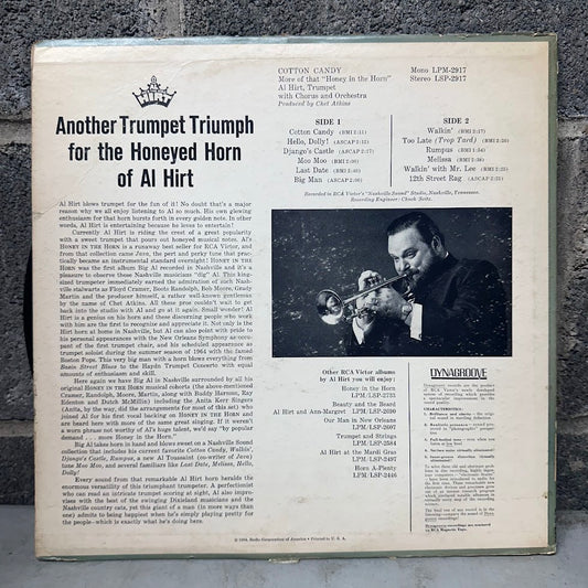 The back cover of a vintage 12-inch vinyl record sleeve for Al Hirt's 'Another Trumpet Triumph for the Honeyed Horn of Al Hirt', laid flat on a dark textured surface. The cover features a black-and-white photo of Al Hirt singing, track listings, and the 'Dinnerclub' label logo.