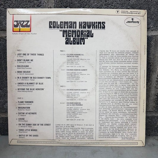 The back cover of the Coleman Hawkins 'Memorial Album' vinyl record, showing track listings and credits on a light beige background with black text, photographed on a dark textured surface.