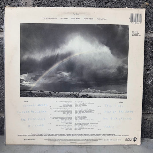 The back cover of a vinyl record sleeve for Paul McCartney's 'Held Back' LP, featuring a dramatic stormy sky with a rainbow over water, photographed on a dark textured surface.