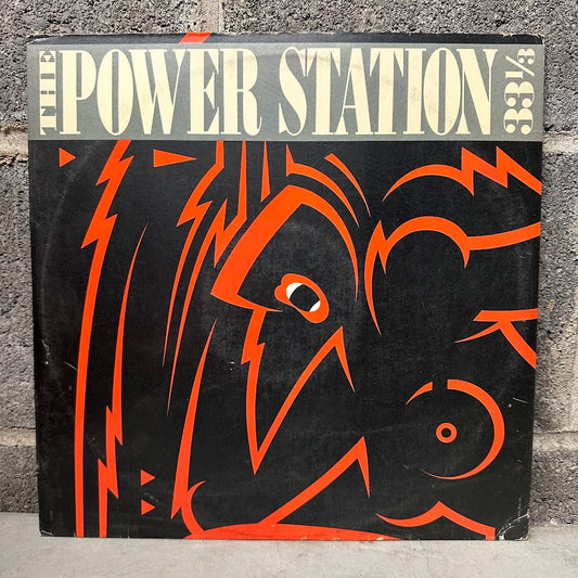 Vinyl record cover with orange graphic design on a black background, featuring the text 'The Power Station' and '33 1/3'.