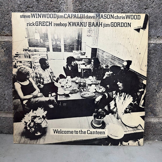 Album cover of 'Welcome to the Canteen' with a black and white photo of people around a table.