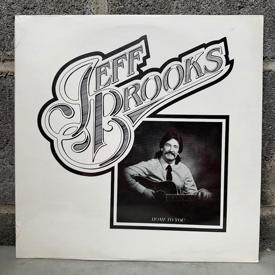 Vinyl record cover with 'Jeff Brooks' and a portrait of a man playing guitar.