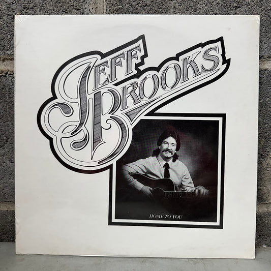 Vinyl record cover with 'Jeff Brooks' and a portrait of a man playing guitar.